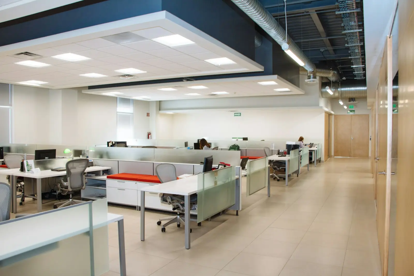 A tidy open-plan office with white desks